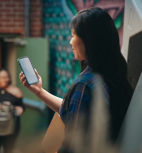 Woman checking smartphone in urban alleyway