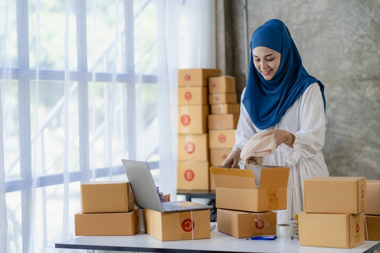A small business owner packing up products from her online clothes business