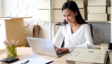 Individual on a laptop using a QuickBooks resource article to learn how to fix issues at the end of a reconciliation