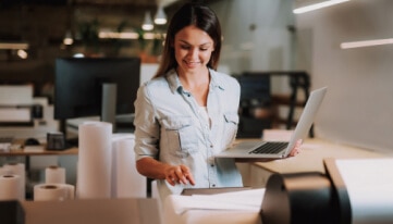 Person on a laptop using QuickBooks resource article to learn how to view, print, or export a reconciliation report