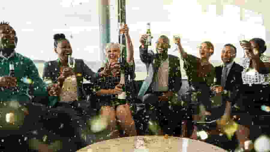 A group of people celebrating with champagne and flowers.