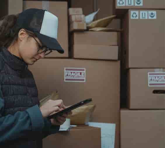 a person using a tablet with shipping boxes