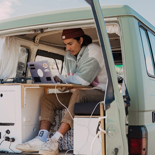 Zac White sitting in a camper van using QuickBooks