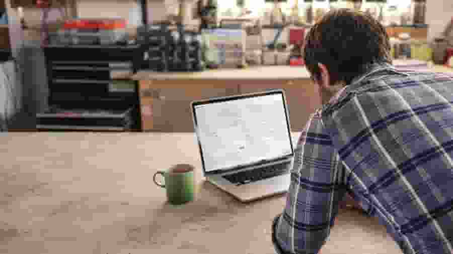 A person sitting at a table with a laptop.