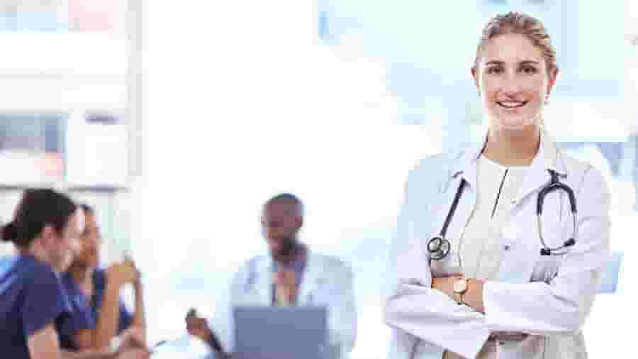 A person in a white lab coat standing next to a person in a white lab coat.