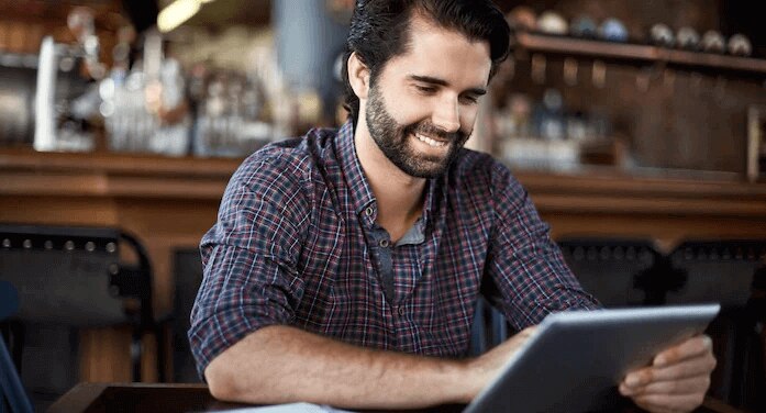 A person sitting at a table with a laptop.