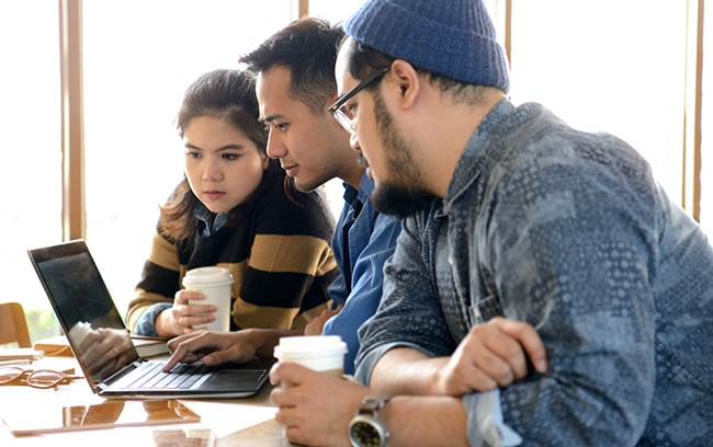 Group of young people looking at laptop