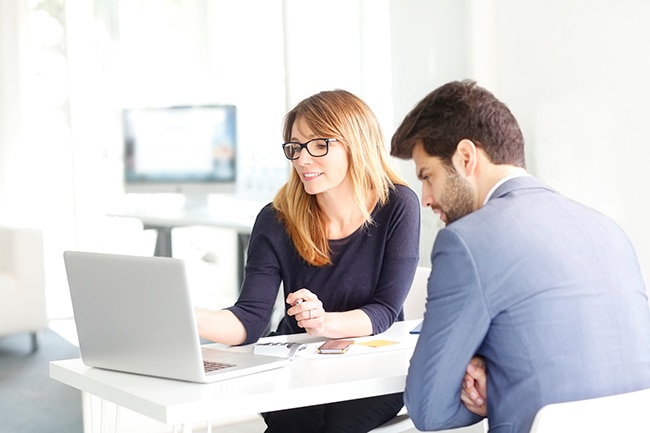 Business man and woman talking over a laptop