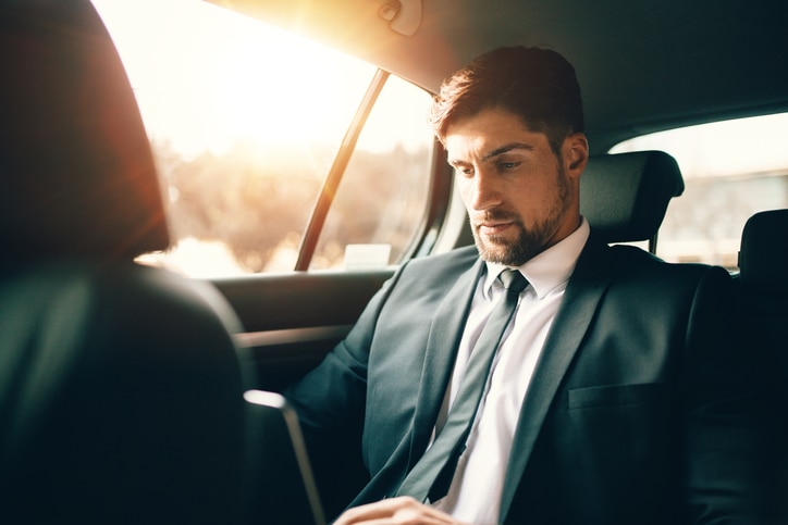 Business man working on laptop in car