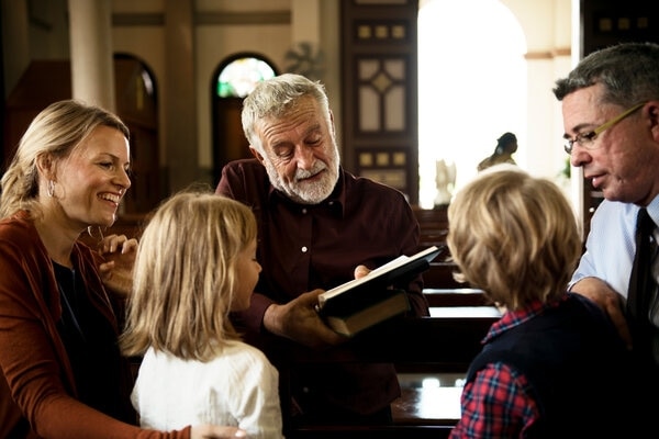 A person and two children sitting in a church.