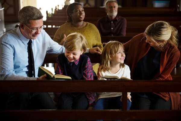 A person reading a book to a group of children.