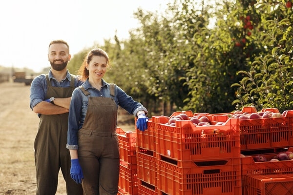 A person and person holding red plastic containers.