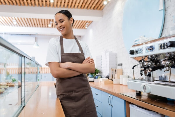 A person standing in a kitchen with a cup of coffee.