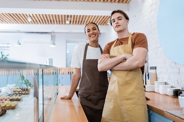 A person and a person standing in a kitchen.