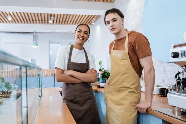 A person and person standing in a kitchen.