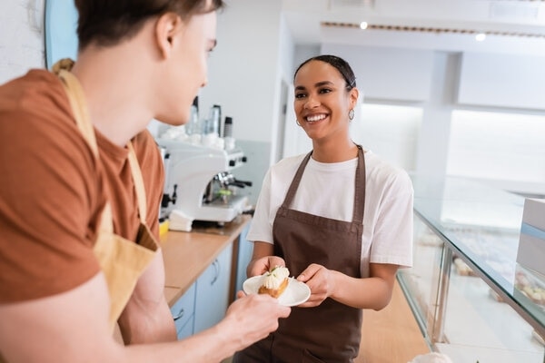 A person holding a tray of food in a kitchen.