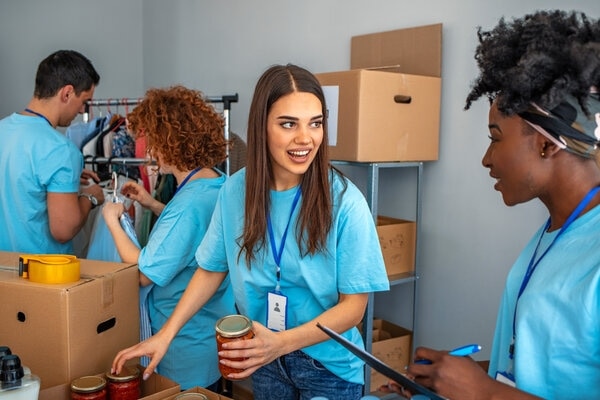 A person is smiling while another person is holding a hair dryer.