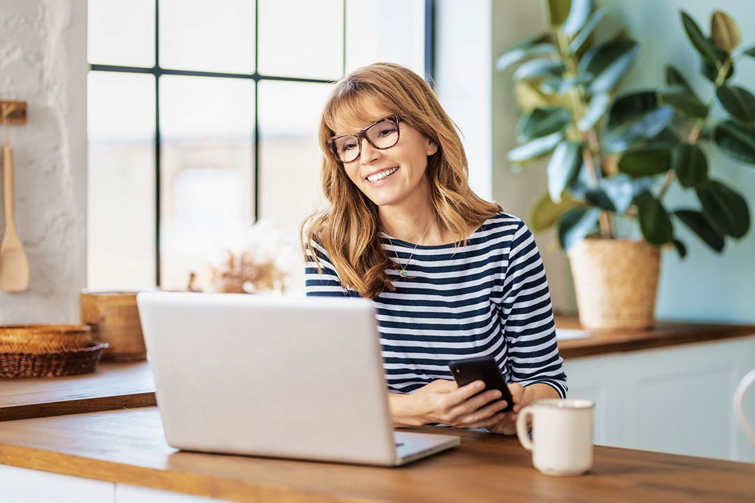 Woman checking payroll software on laptop