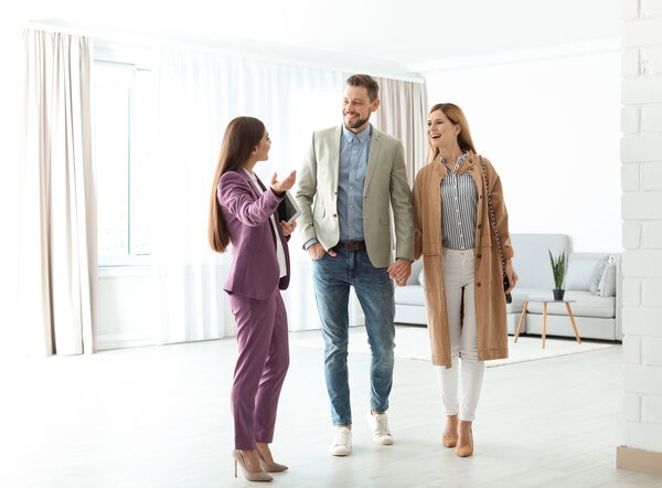 Three people in a room with a wall of windows.