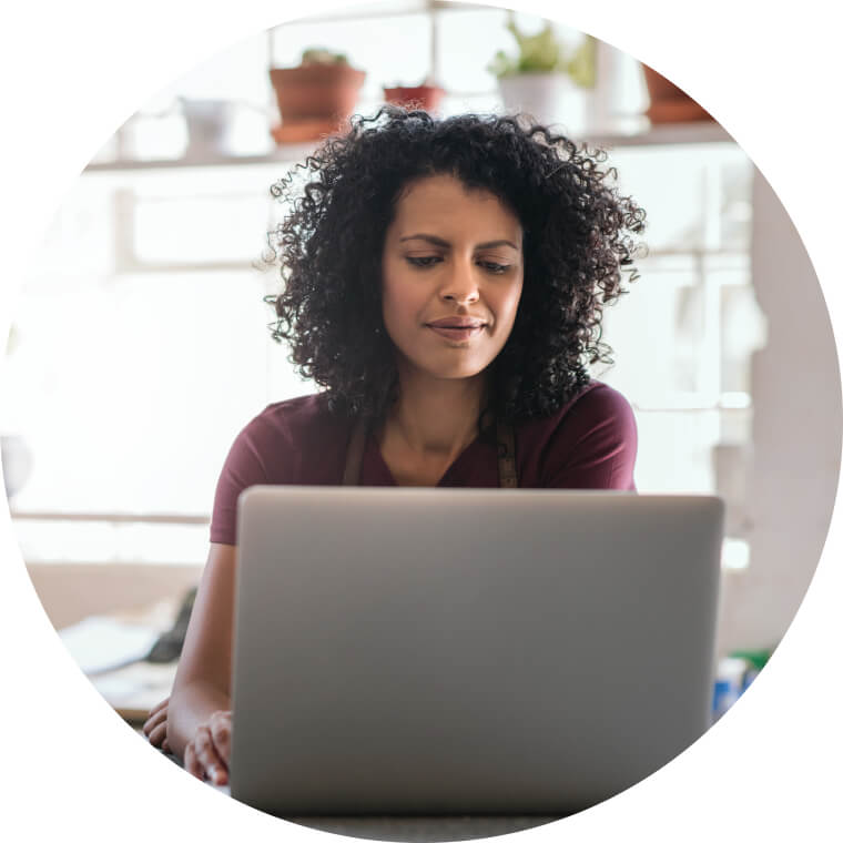 a woman concentrating whilst looking at a laptop screen.