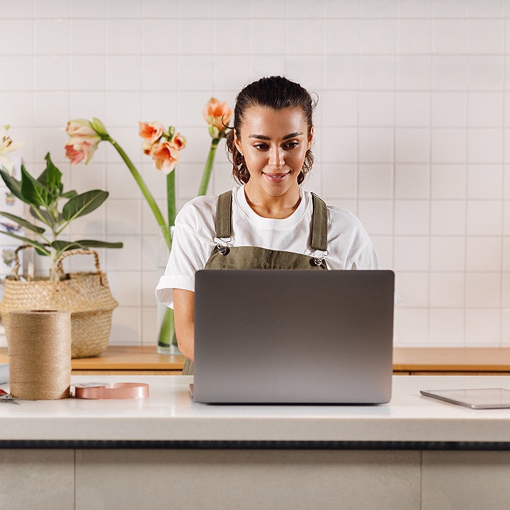 A person is sitting at a table with a laptop.