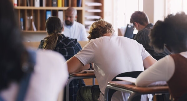 A group of people sitting at a table with laptops.