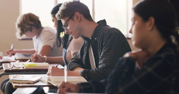 A person sitting at a table with a laptop computer.