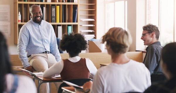 A person sitting at a table with two children.