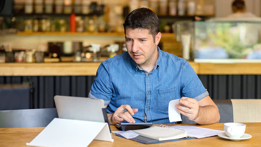 Man utilising the weekly tax table using QuickBooks on tablet