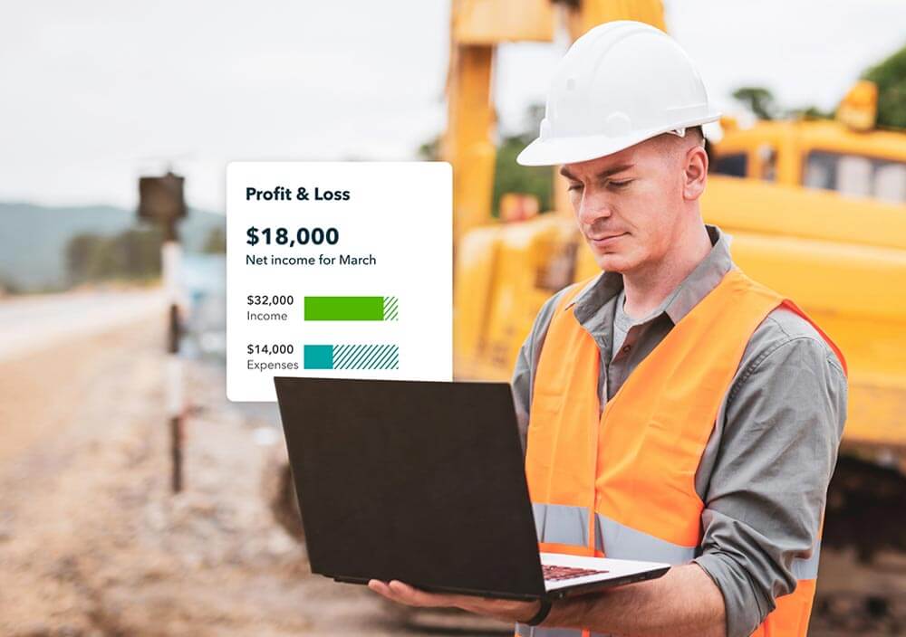 A person in a construction site holding a mobile device.