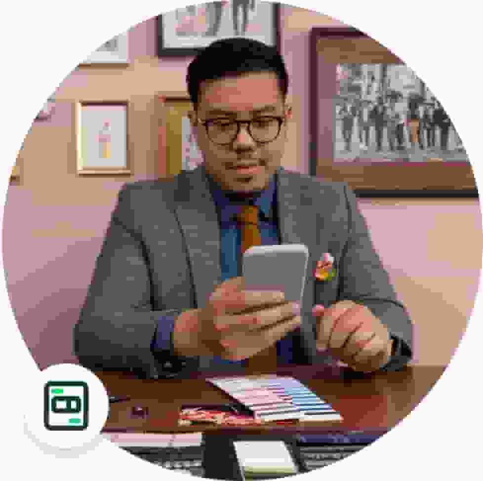 A man looking at his phone on how to enable Payroll on QuickBooks