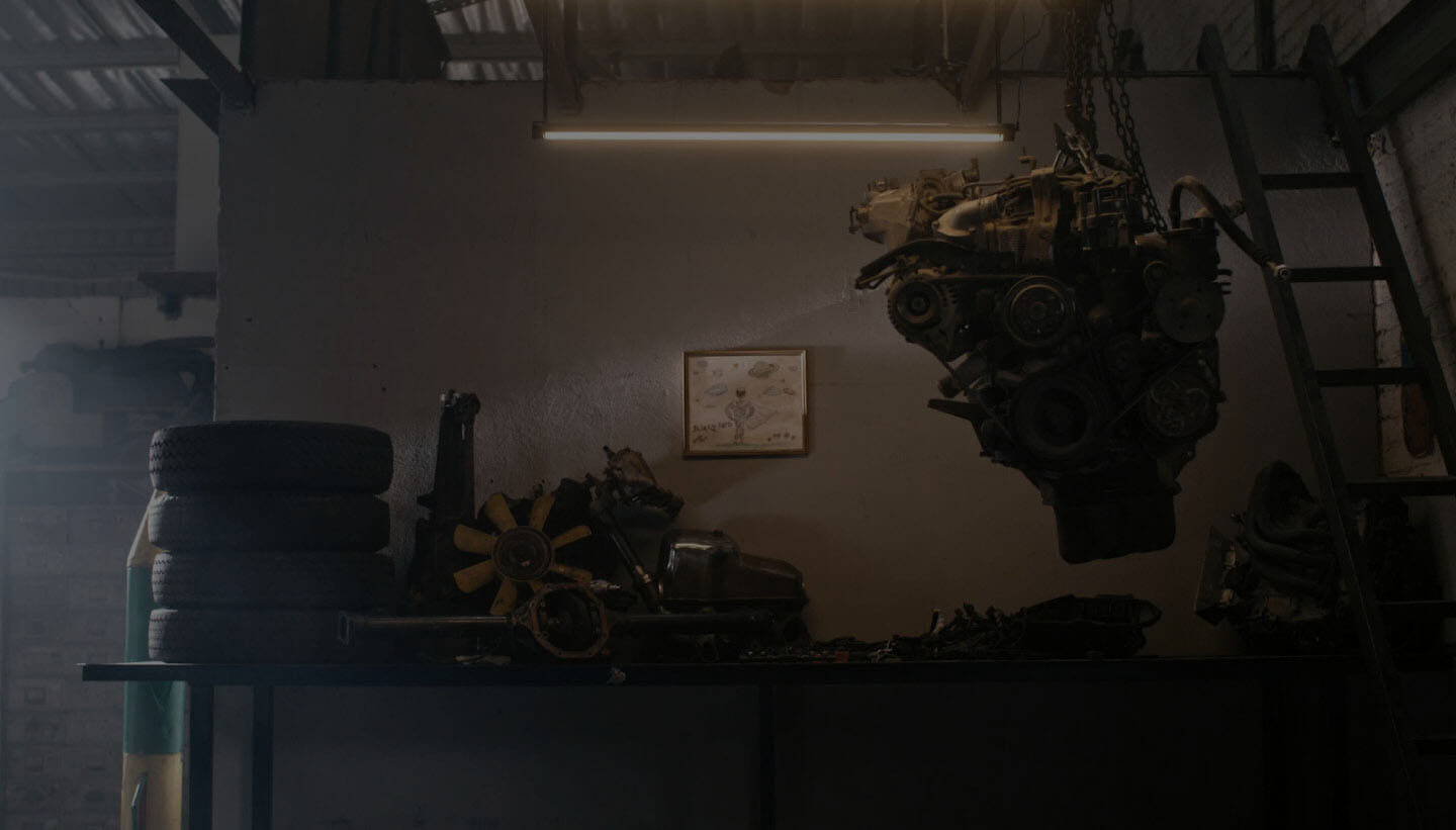 A car parked next to a bunch of old motorcycles.