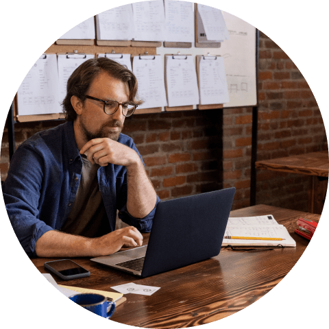 Man on laptop using QuickBooks to manage bookkeeping