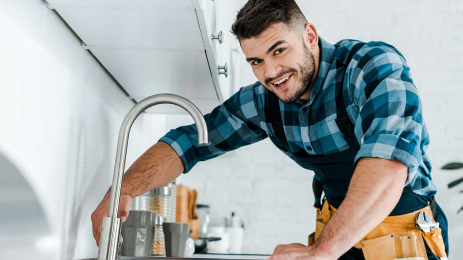 A person is pouring something into a sink.