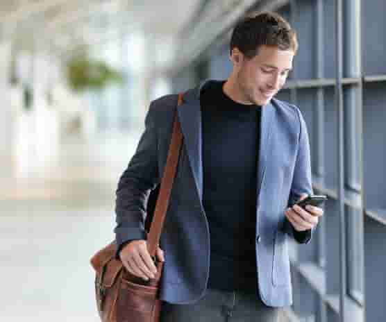 An employee arriving at job site while clocking in using their mobile phone