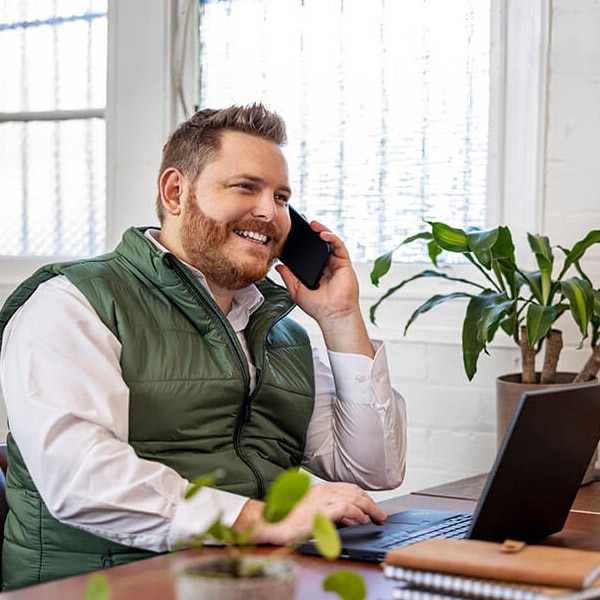 An accountant talking to someone on the phone finding out about the advisor-only pricing from QuickBooks Online Accountant