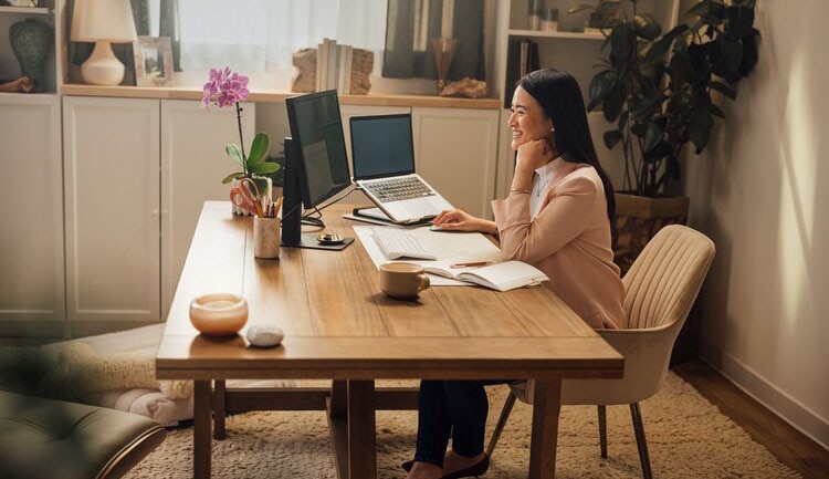 A person sitting at a table with a laptop computer.