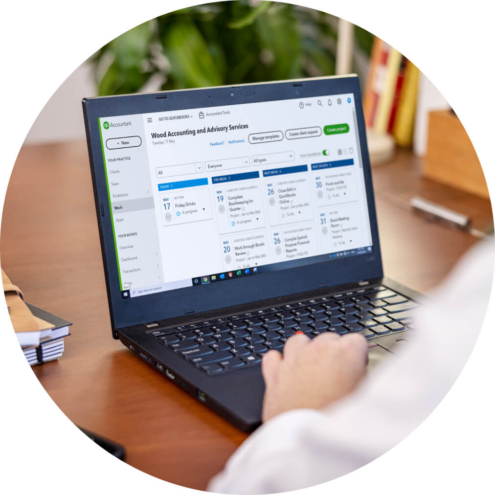 Person at desk using laptop with QuickBooks dashboard displayed