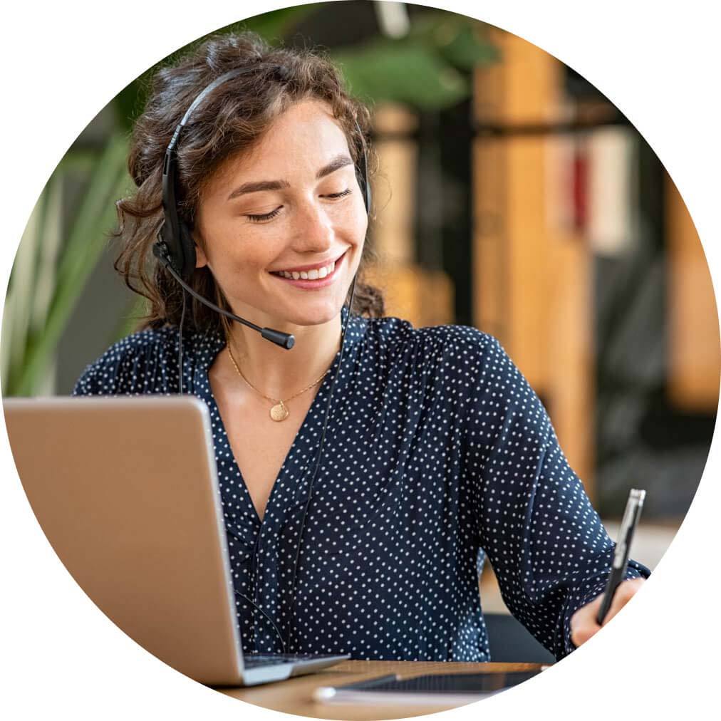 A person sitting at a desk with a laptop and headphones on.