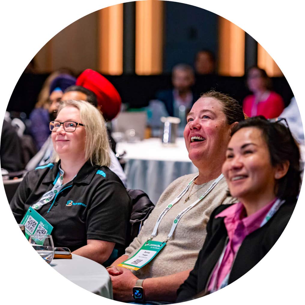 Room of attendees smiling at a QuickBooks Roadshow Event