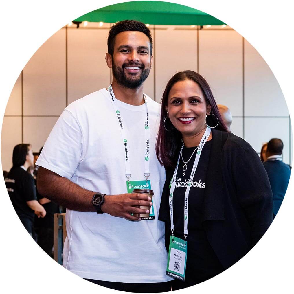 Two attendees posing and smiling together at a QuickBooks Roadshow Event