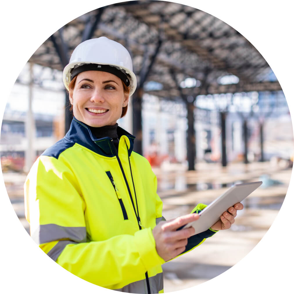 Woman in a construction jacket, using QuickBooks app on a tablet