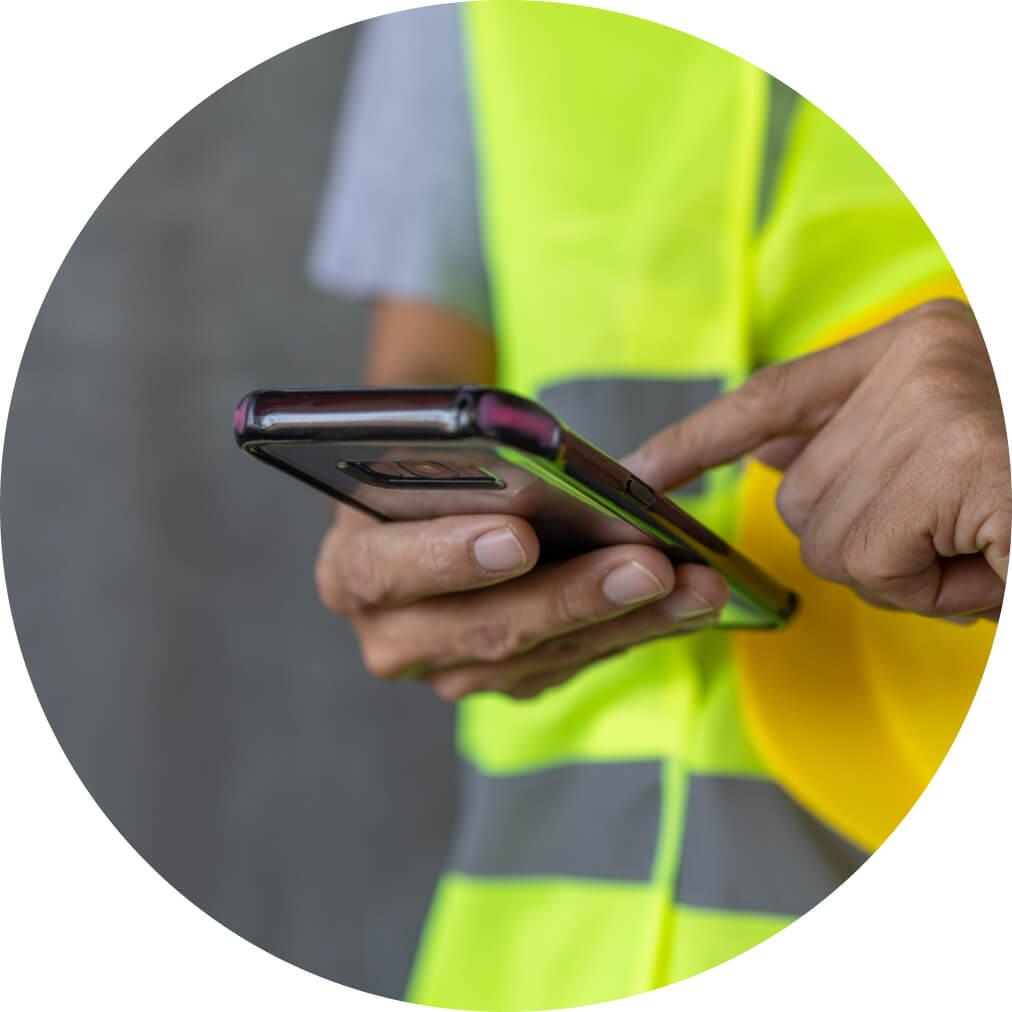 Construction worker using QuickBooks app on a mobile phone