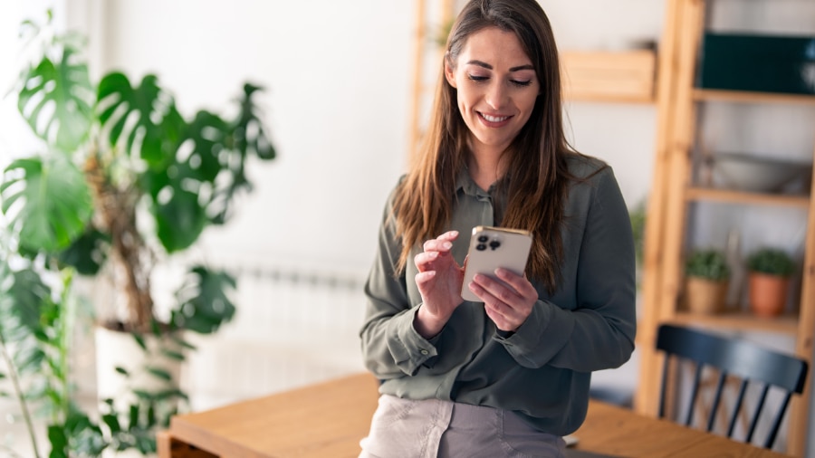 A woman holding a smart phone in her right hand.