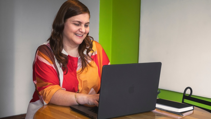 Amanda Mungal sitting at a desk with a laptop.