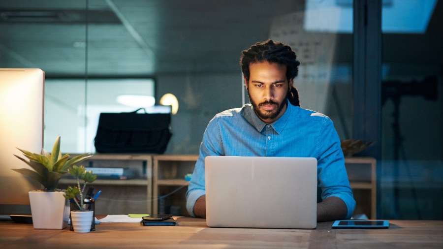 A person sitting at a desk with a laptop computer.