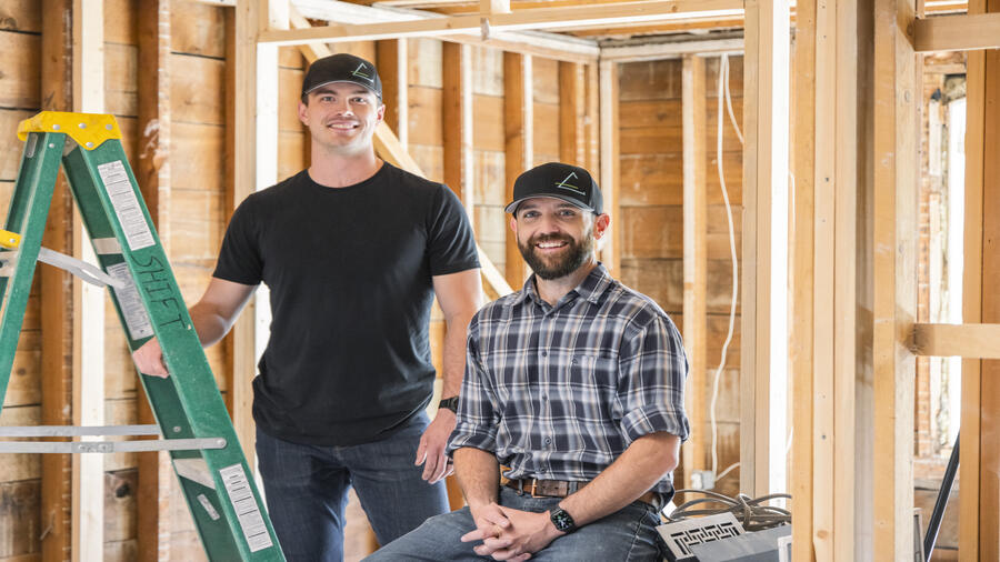 Two people in a construction site smiling 