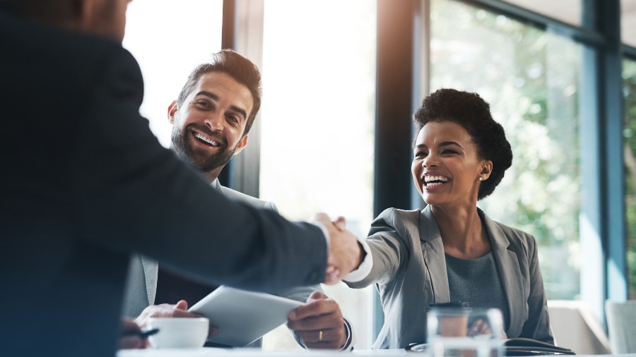 A group of people are having a discussion and shaking hands.