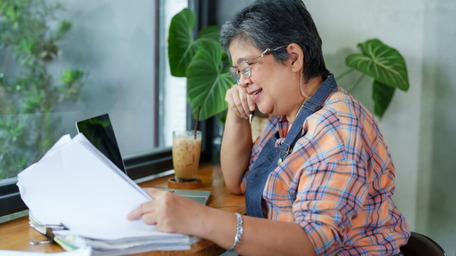 A woman sitting at a table looking at statements