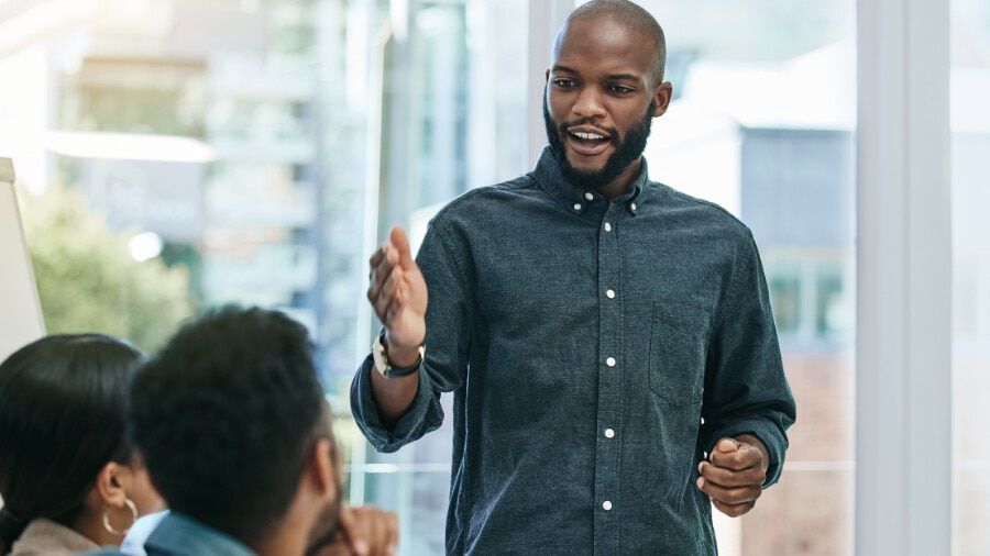 A person is talking to others in a meeting.